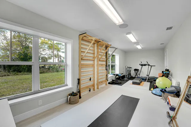 a view of an empty room with wooden floor and windows