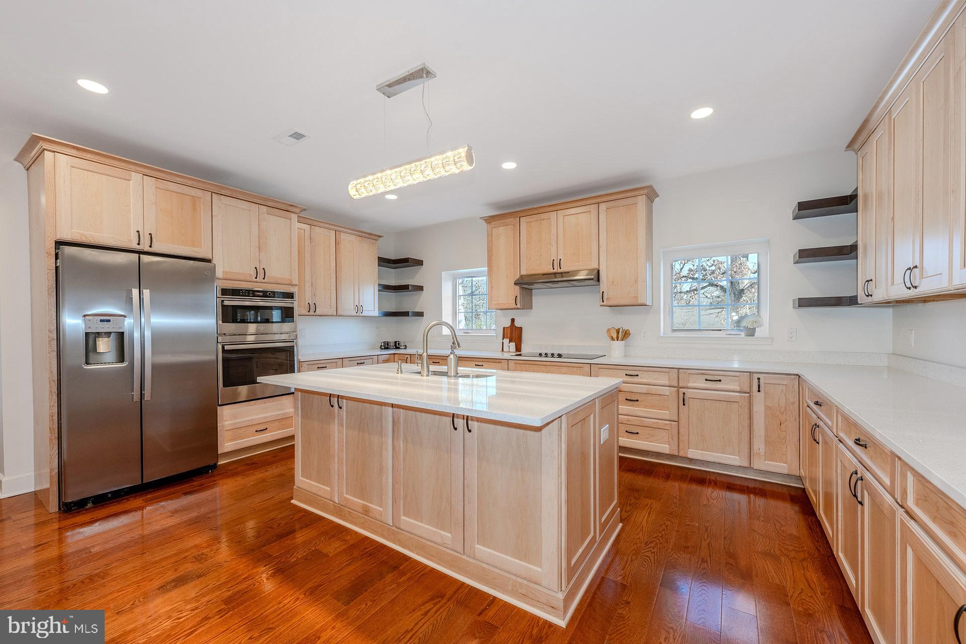 12300 Braddock Road Fairfax, VA 22030 - Photo 20 of 70 a kitchen with stainless steel appliances granite countertop a stove a sink dishwasher a refrigerator and white cabinets with wooden floor
