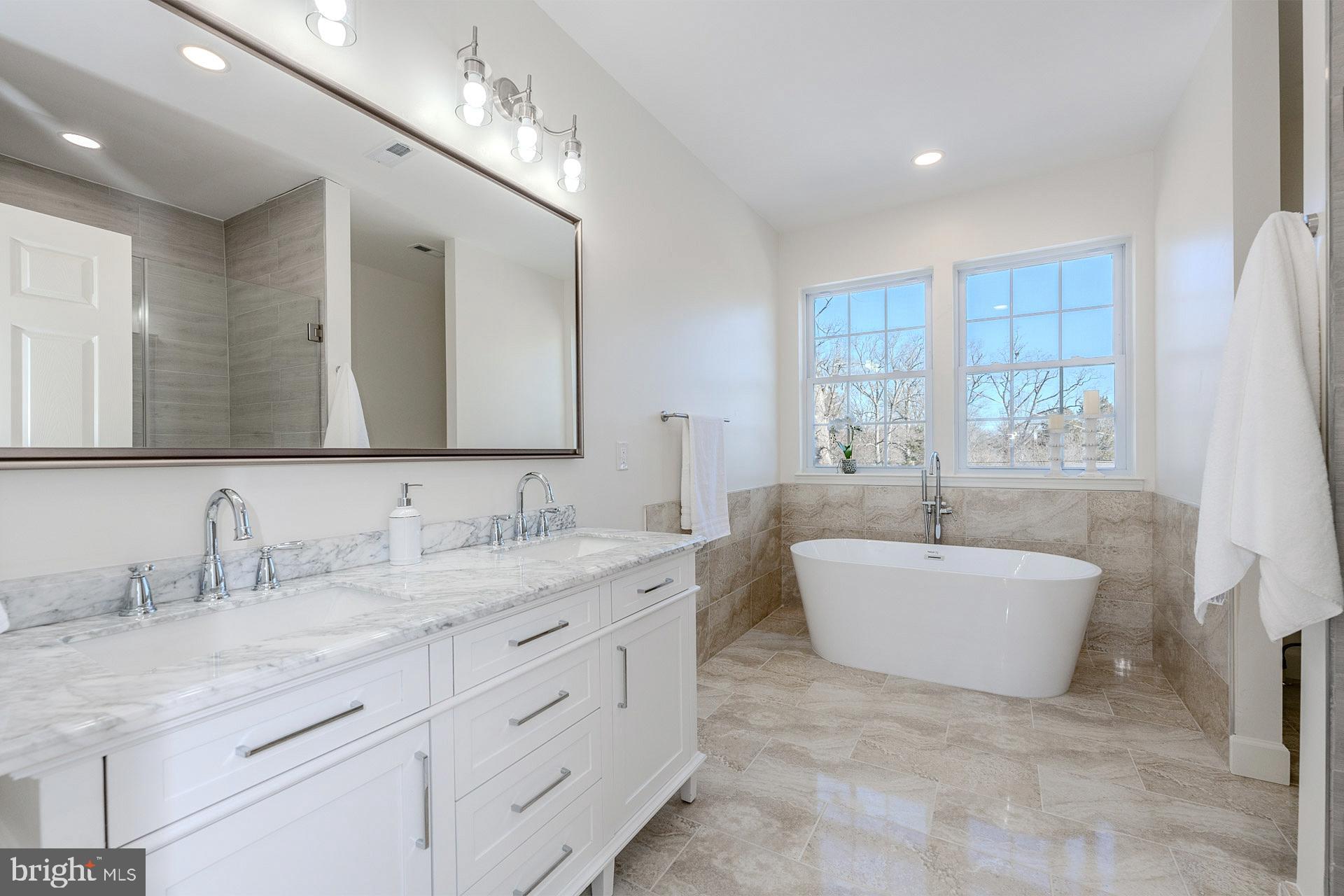 12300 Braddock Road Fairfax, VA 22030 - Photo 42 of 70 a spacious bathroom with a double vanity sink large mirror and bathtub