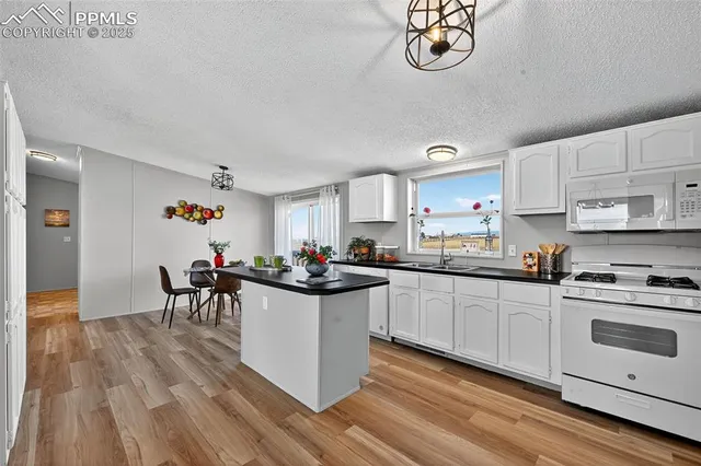 a kitchen with a dining table chairs and view living room