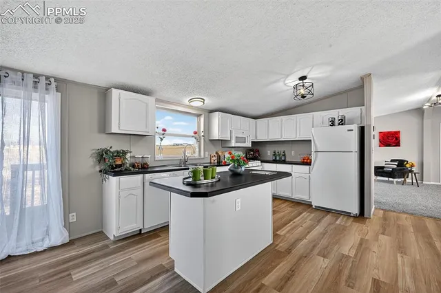 a kitchen with granite countertop a sink dishwasher stove and cabinets