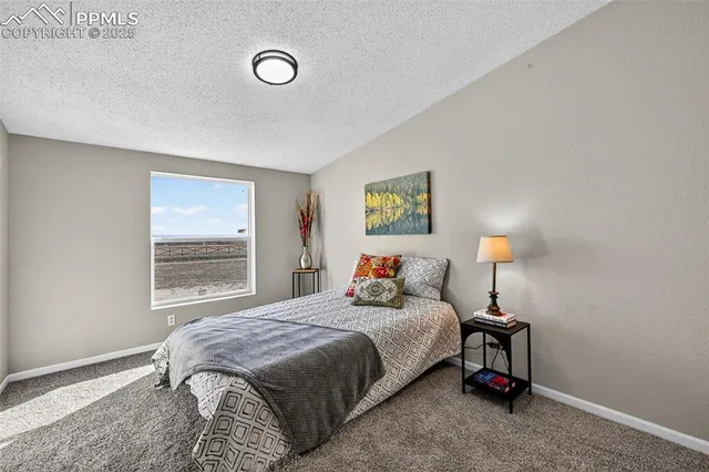a bedroom with a bed and painting on the wall