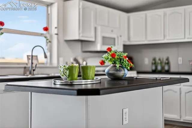 a kitchen with white cabinets and a granite counter tops