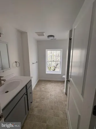 a bathroom with a toilet a sink and a window