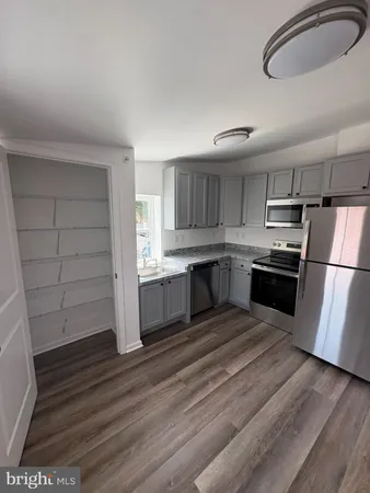 a kitchen with wooden floors and appliances