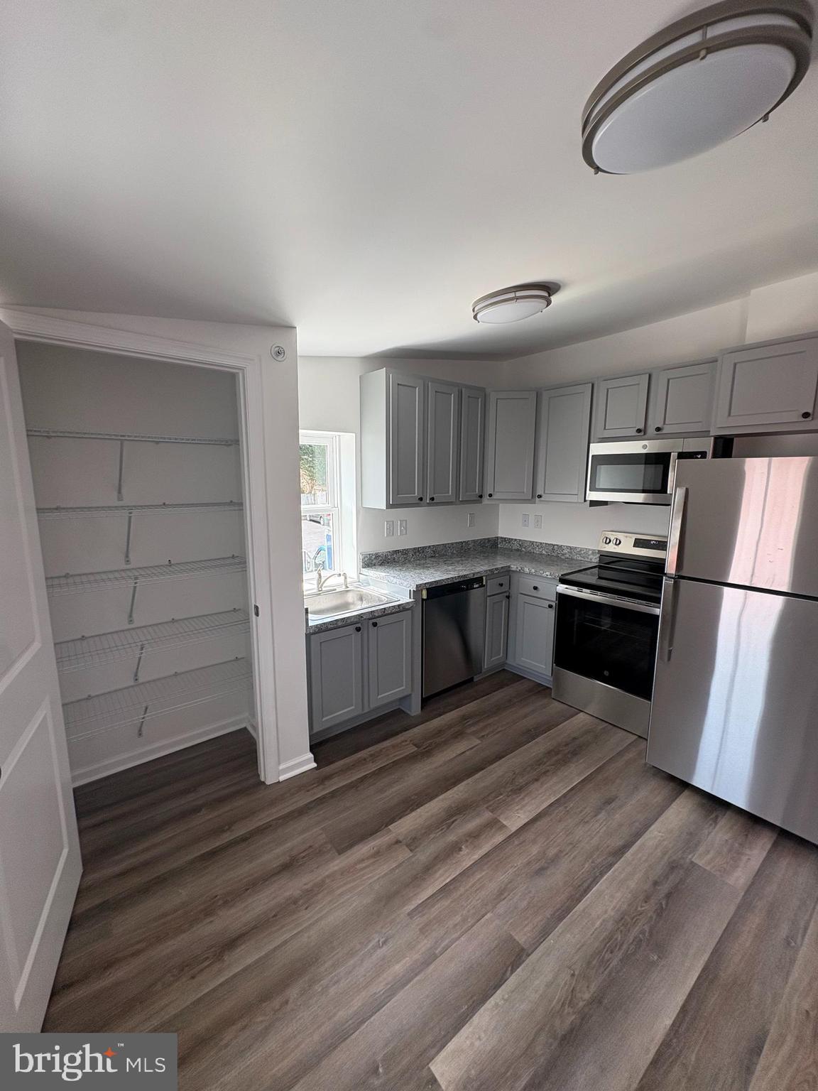 104 West All Saints Street, Unit C2 Frederick, MD 21701 - Photo 9 of 19 a kitchen with wooden floors and appliances