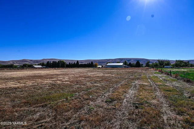 a view of a chair and table in backyard of the house