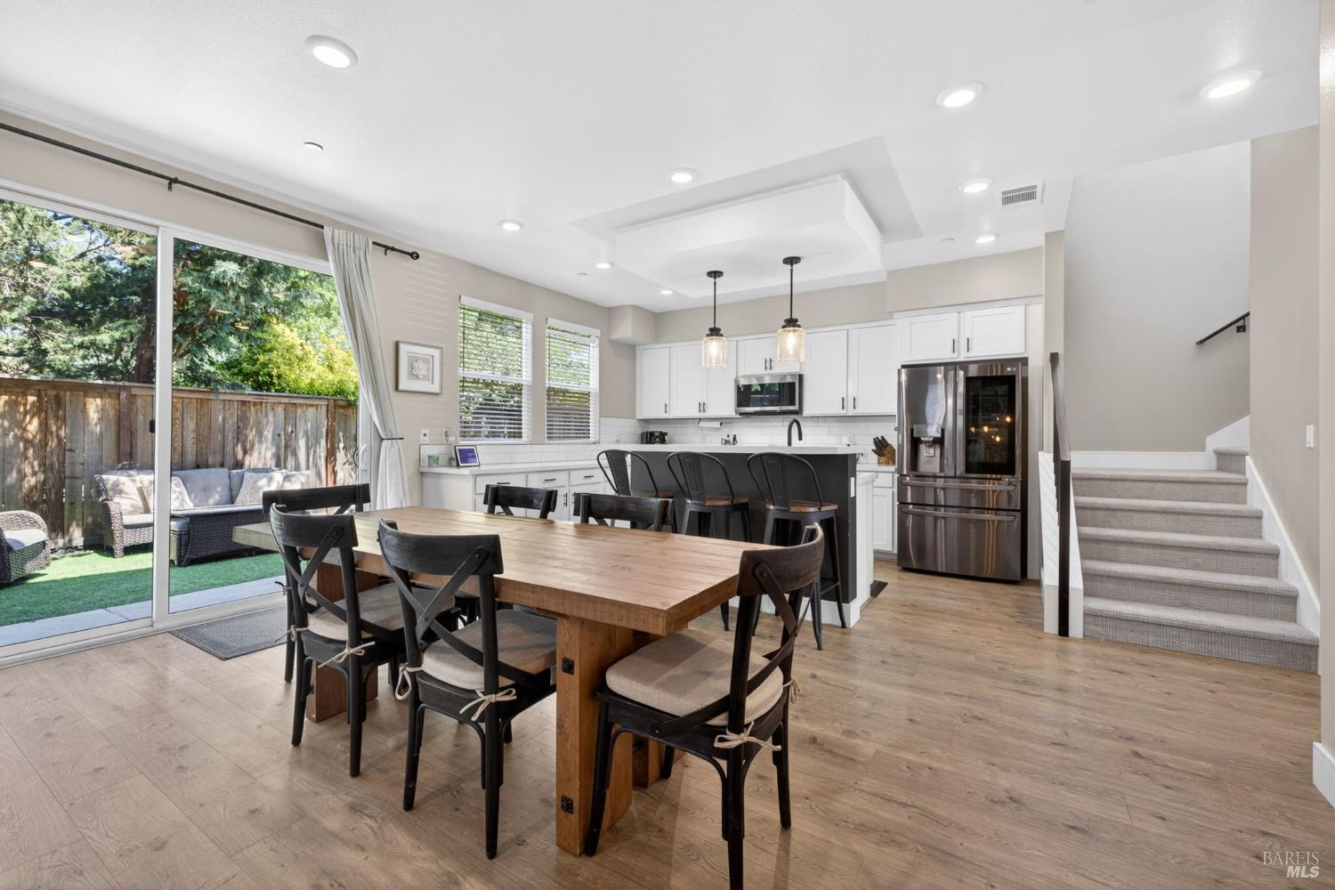 2215-2217 Versaro Drive Santa Rosa, CA 95403 - Photo 10 of 45 a view of a dining room and livingroom with furniture wooden floor a rug a fireplace and a chandelier