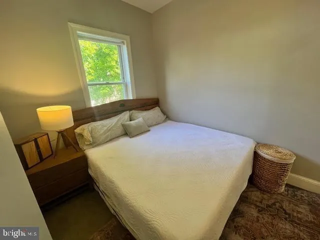 a bed sitting in a bedroom next to a window