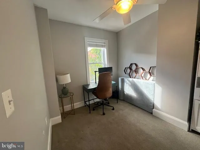 a view of a workspace with furniture and a window