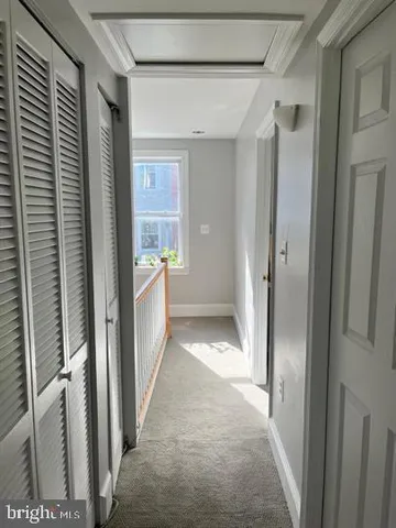 a view of a hallway with wooden shelves