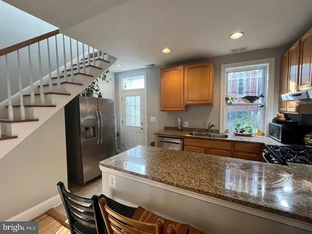a kitchen with sink refrigerator and window