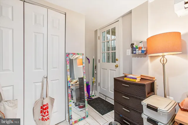 a bedroom with a bed and a lamp on the dresser