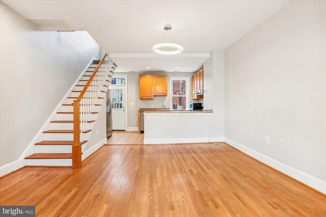 a view of a kitchen with wooden floor and a window