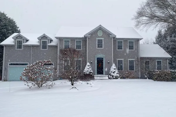 a view of a house with a yard covered in snow