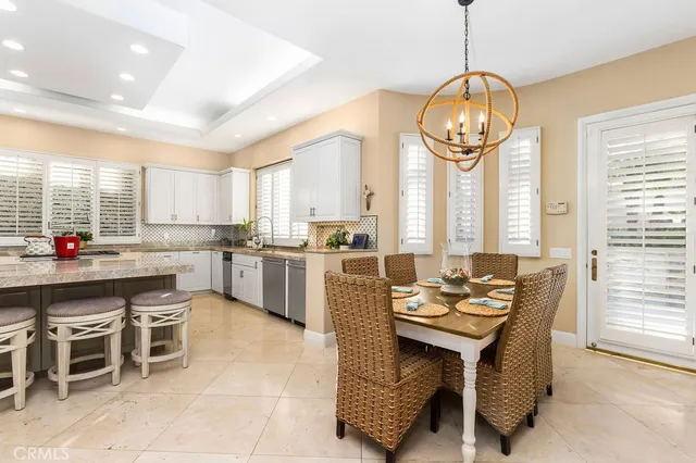 a open kitchen with stainless steel appliances granite countertop a stove refrigerator dining table and chairs