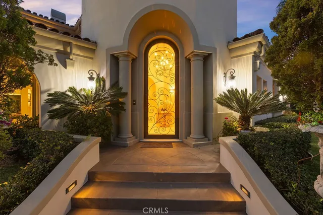 a view of a house with large windows and a flower garden
