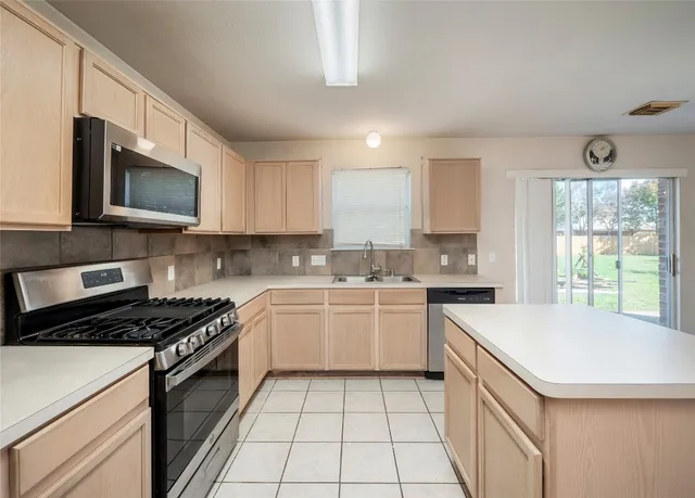 a kitchen with a stove a sink and a microwave
