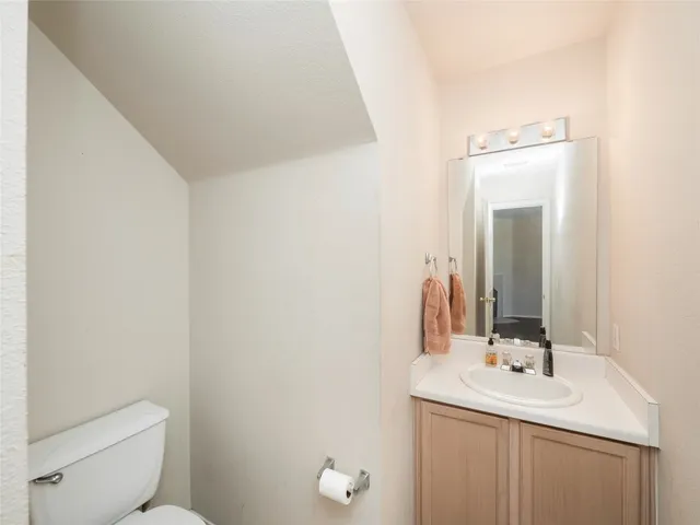 a bathroom with a toilet a sink a mirror and vanity
