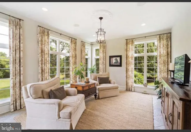 a living room with stainless steel appliances furniture a fireplace and a flat screen tv