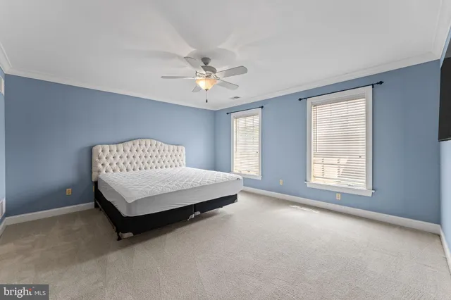 a view of an empty room with wooden floor and stairs