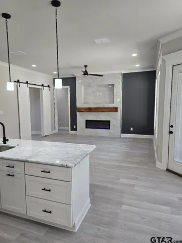 a kitchen with granite countertop white cabinets and black appliances