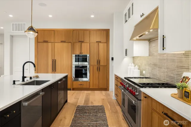 a kitchen with stainless steel appliances granite countertop a sink and cabinets