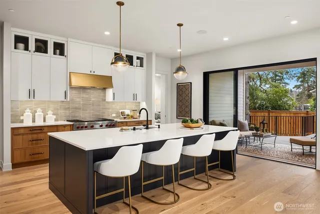 a kitchen with a dining table chairs sink and white cabinets