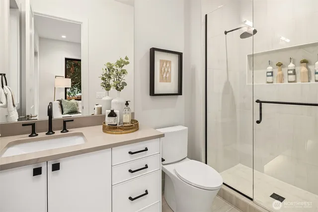 a bathroom with a granite countertop sink toilet and shower