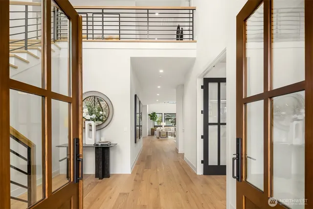 a view of a hallway with wooden floor and a kitchen view