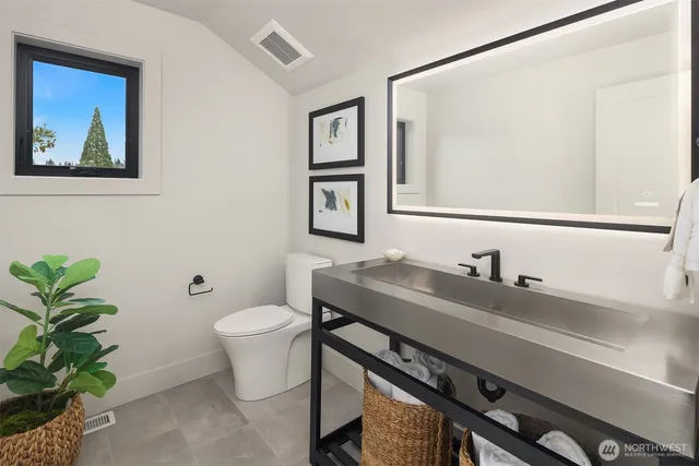 a bathroom with a toilet a sink and mirror