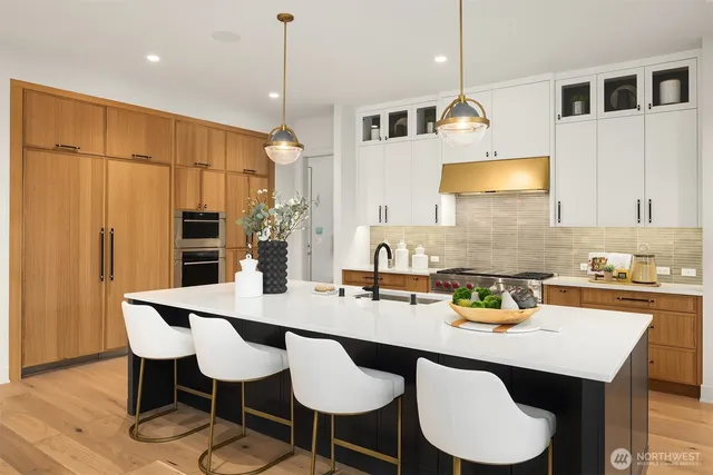 a kitchen with stainless steel appliances granite countertop a table chairs stove and kitchen island