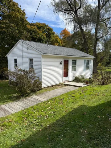a view of backyard of house with green space