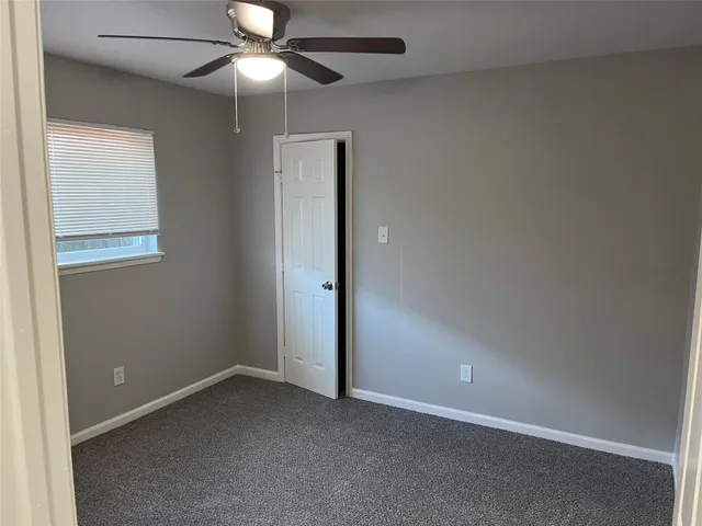 an empty room with closet and a chandelier fan