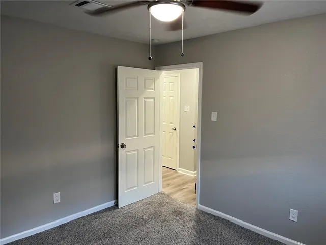 an empty room with a chandelier fan