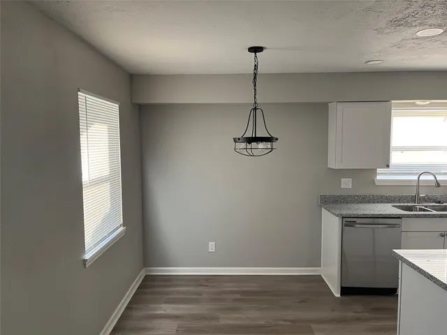 a view of empty room with window and wooden floor