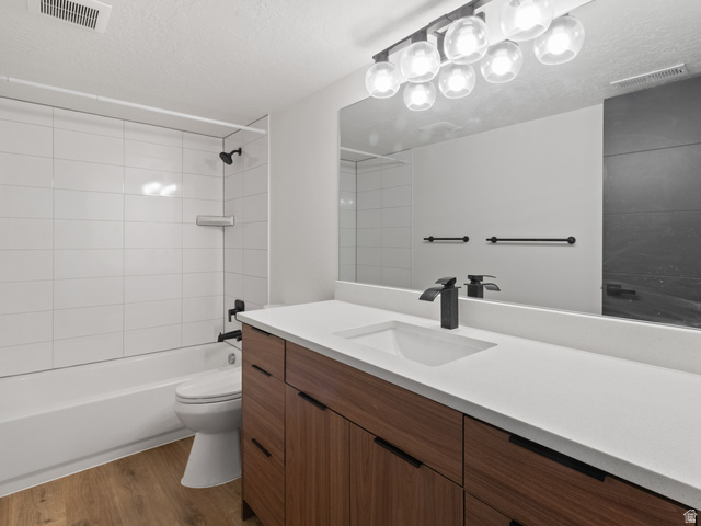 130 East 7085th South, Unit 3 Midvale, UT 84047 - Photo 23 of 30 Full bathroom with vanity, bathtub / shower combination, dark wood finished floors, and a textured ceiling