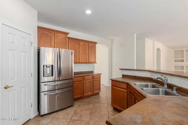 a kitchen with stainless steel appliances granite countertop a refrigerator sink and stove