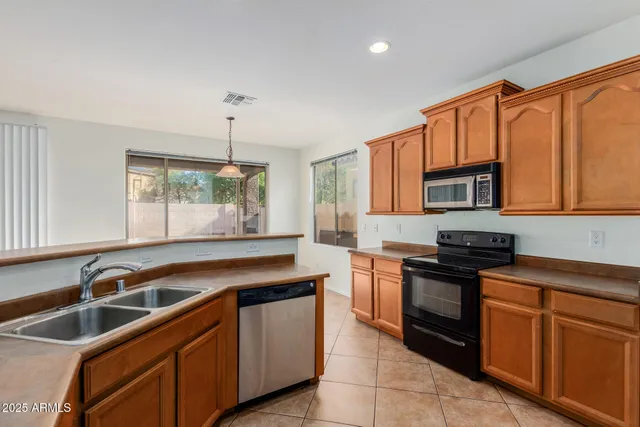 a kitchen with granite countertop a sink stove and cabinets