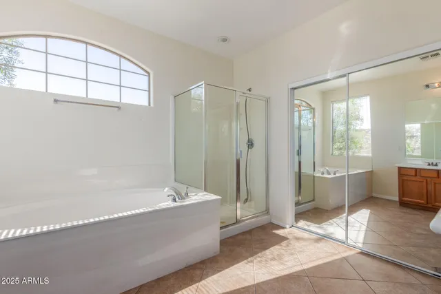 a spacious bathroom with a tub shower and window