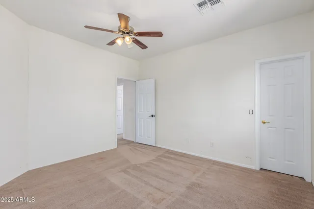 an empty room with a window and a ceiling fan