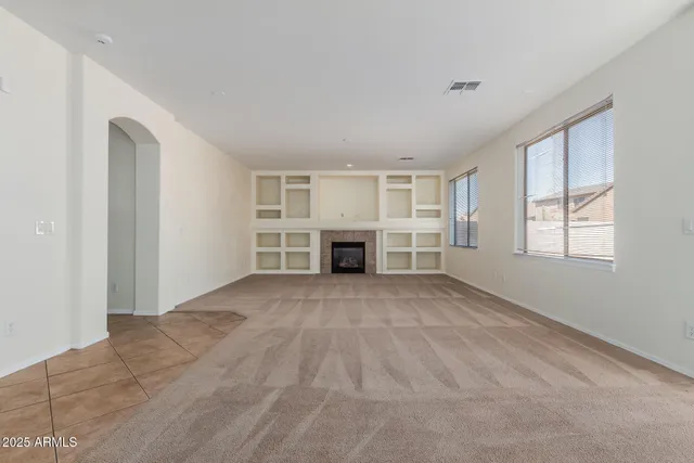 a view of empty room with a fireplace and window