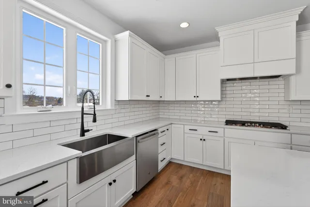 a kitchen with granite countertop a sink stove and cabinets
