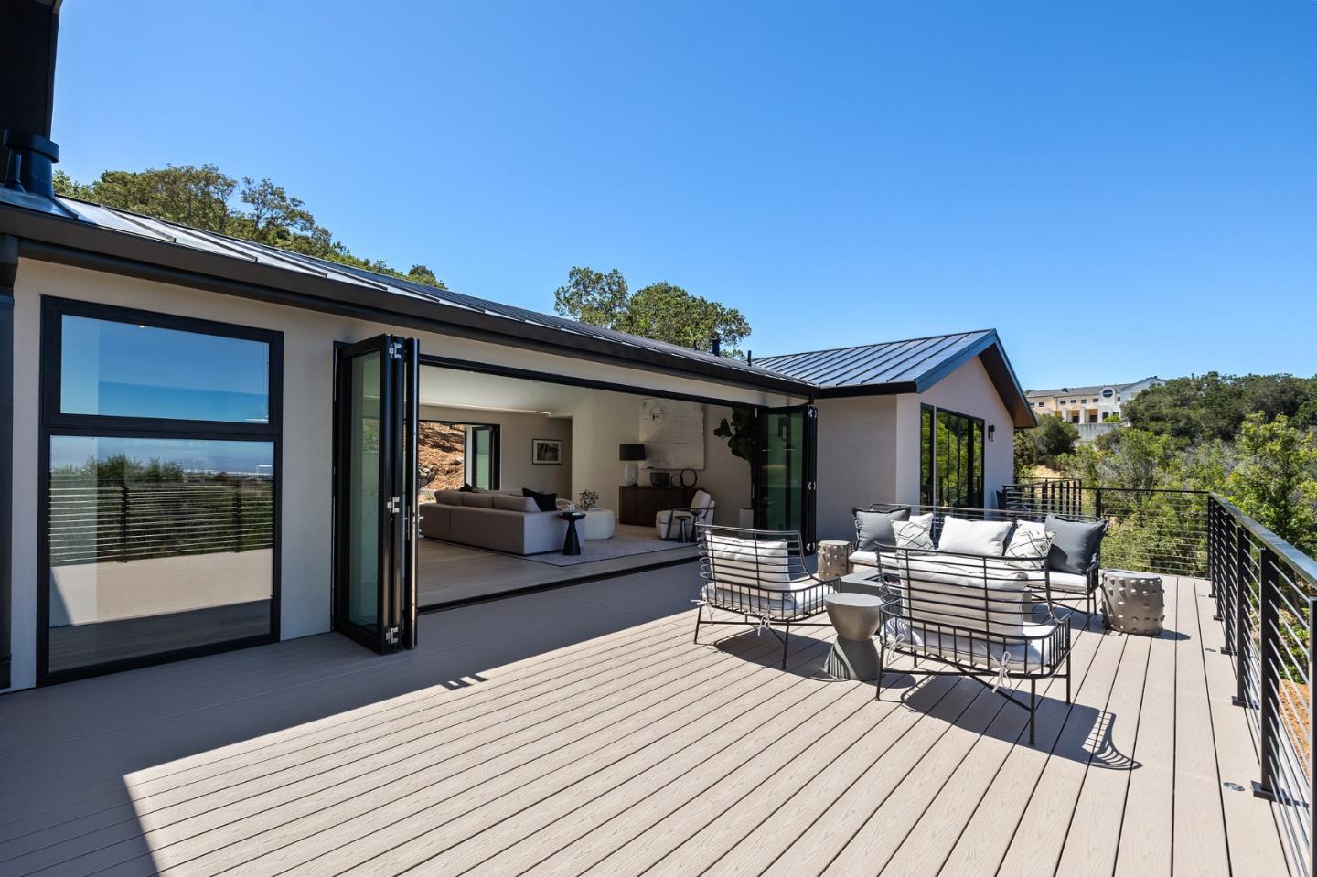 255 Hardwick Road Woodside, CA 94062 - Photo 26 of 90 a view of a patio with couches table and chairs with wooden floor and fence
