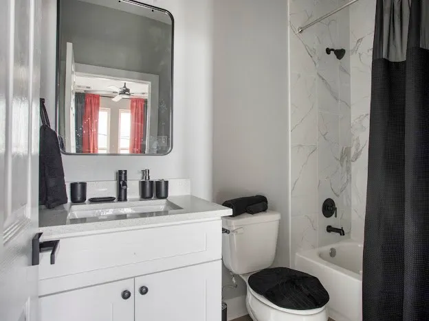 a bathroom with a granite countertop sink toilet and shower