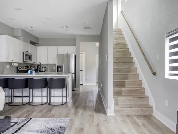 a kitchen with granite countertop wooden floors wooden cabinets and stainless steel appliances