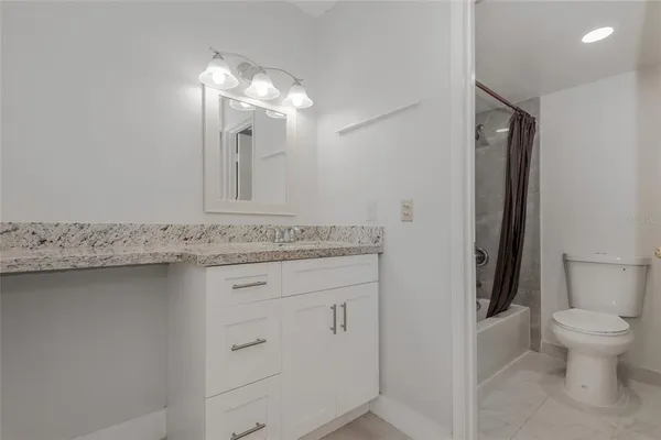 a white toilet sitting next to a bath tub
