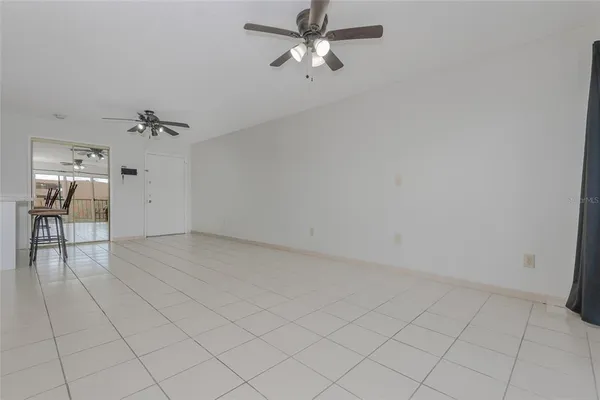 a view of a livingroom with a chandelier fan and windows