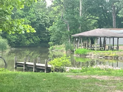 a backyard of a house with table and chairs under an umbrella