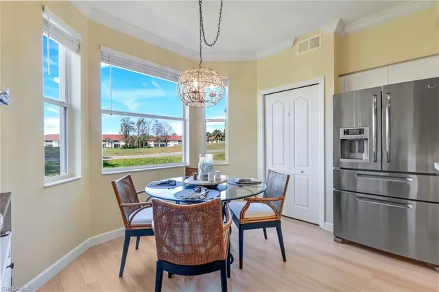 a dining room with furniture a chandelier and wooden floor